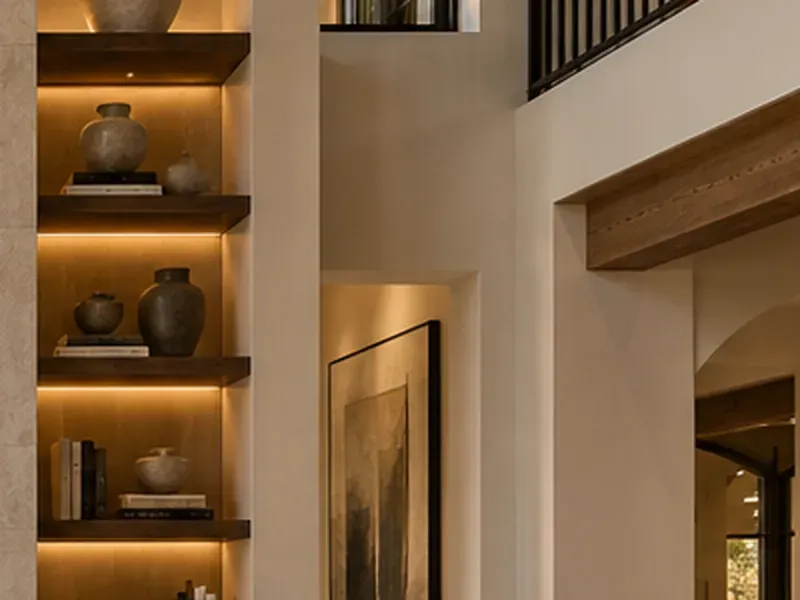 Design concept of lit wood floating shelves holding pottery and books