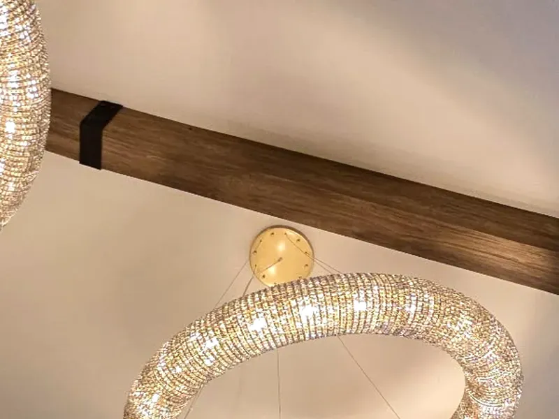 Close-up of a dark stained real wood ceiling beam with a black strap detail