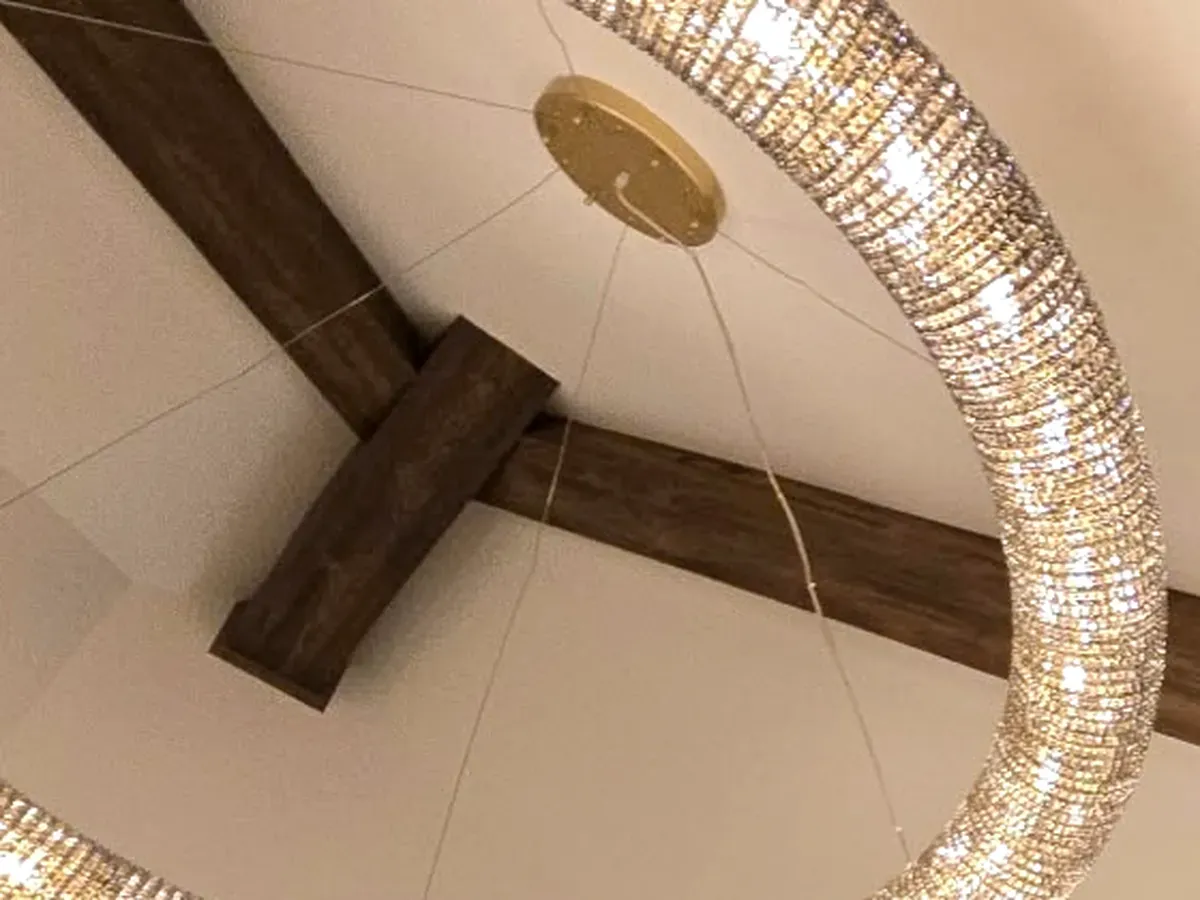 Two real wood box beams meeting at a cross joint on a vaulted ceiling, built by Chava Grain & Beam by Chava Home Design