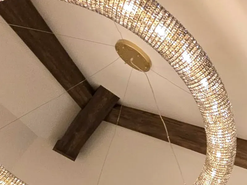 Two real wood box beams meeting at a cross joint on a vaulted ceiling